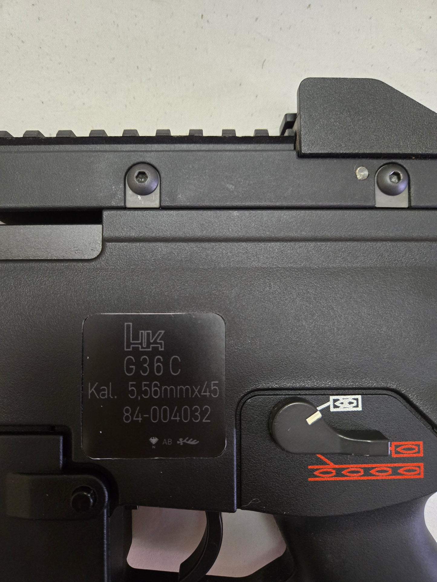 Close-up of a black firearm with visible branding and model details on a light gray background