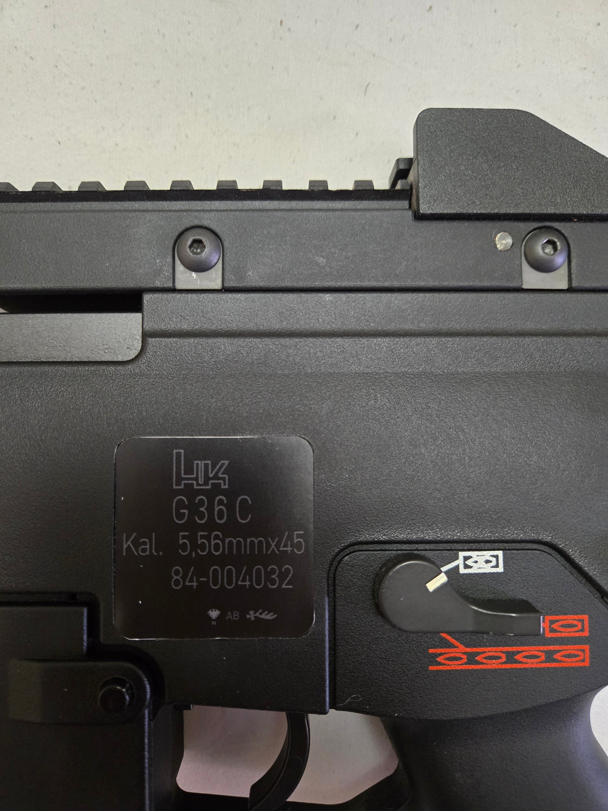 Close-up of a black firearm with visible branding and model details on a light gray background