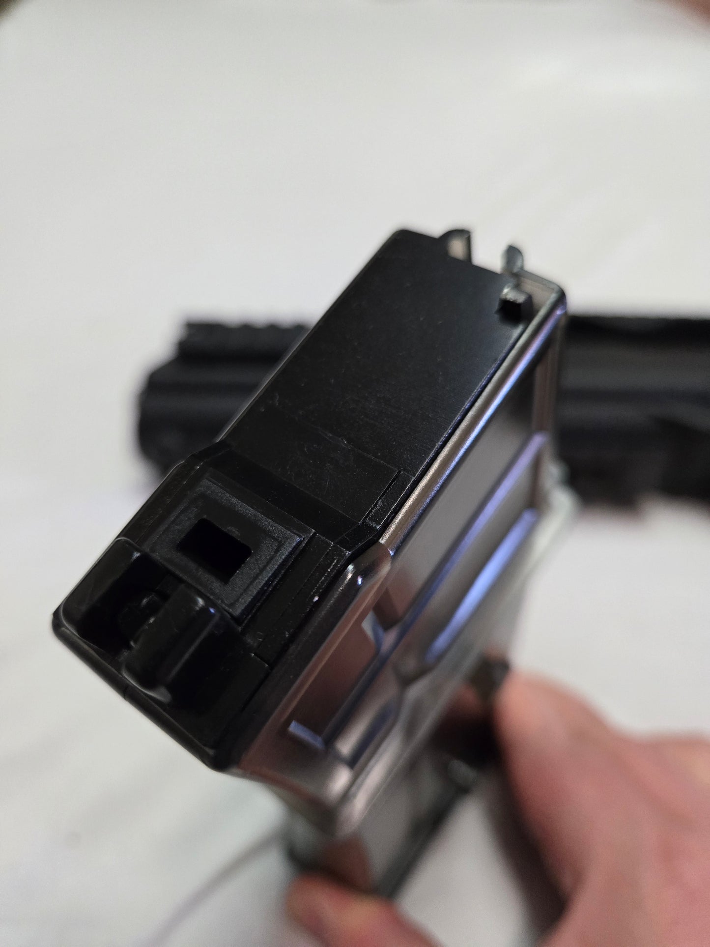 Close-up of a black electronic device with a person's hand holding it.